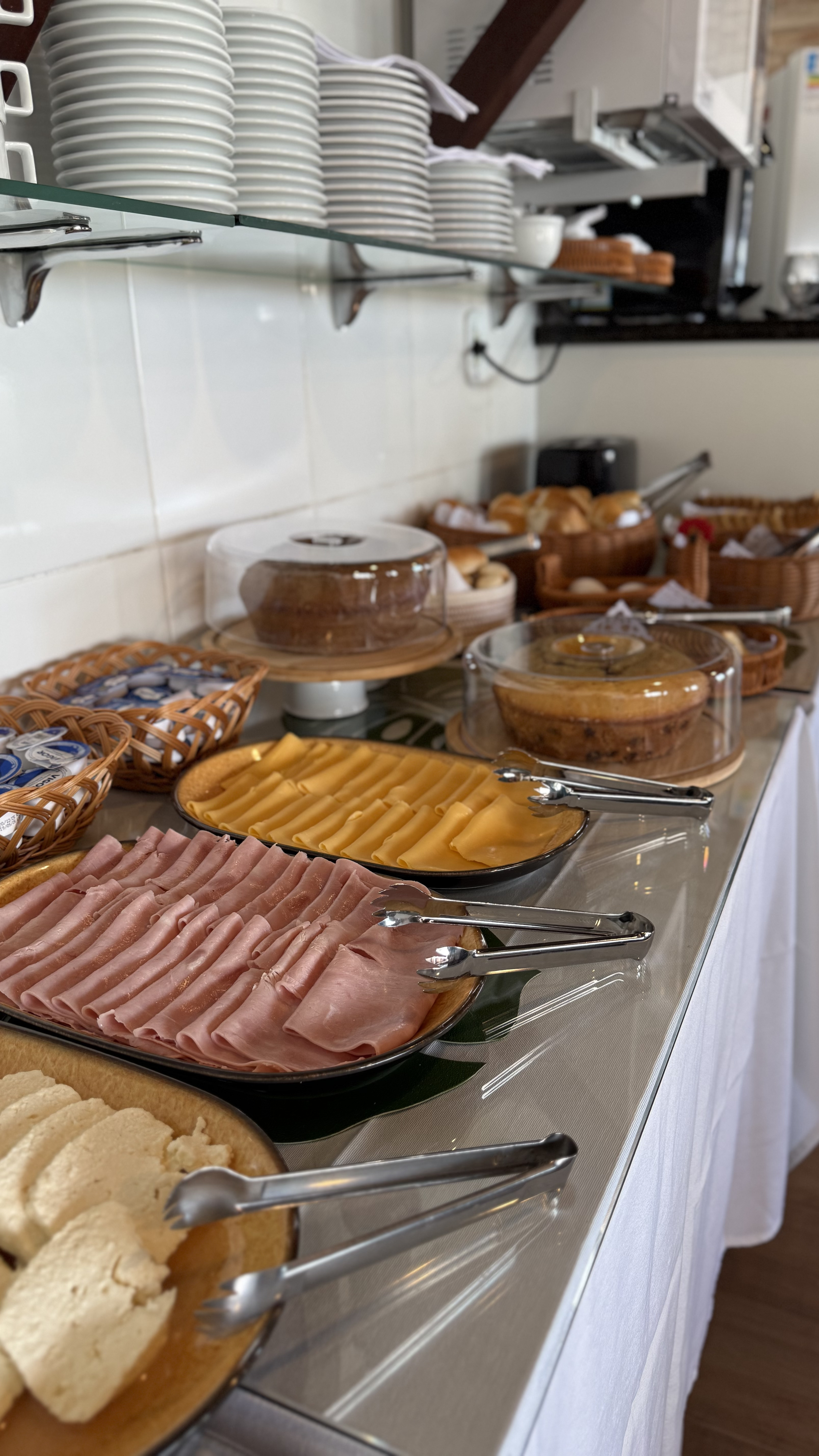 Buffet completo do café da manhã da Pousada Mar da Vila com bolos, frios e cestas