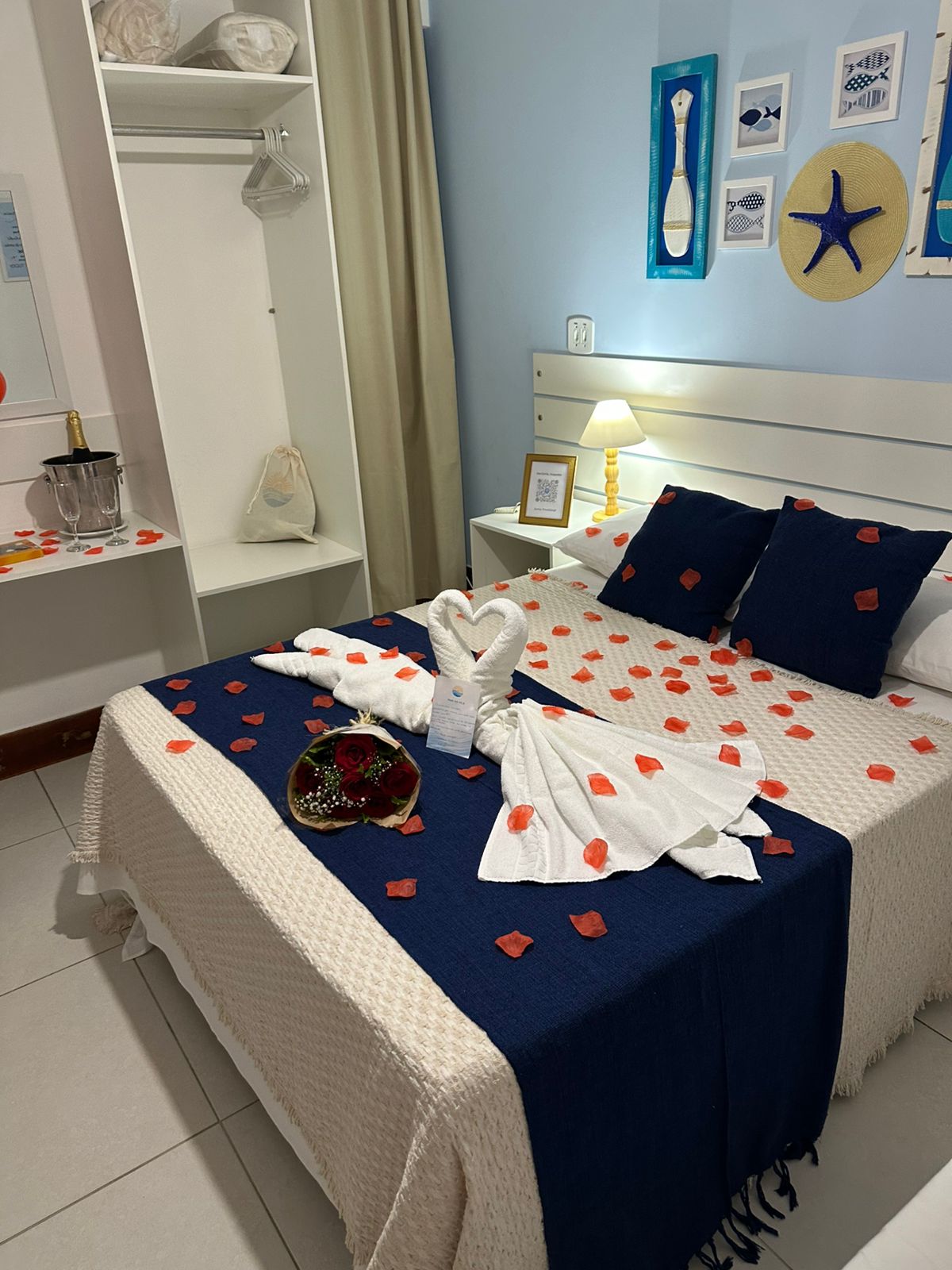 Quarto com decoração romântica completa, pétalas de rosas e champanhe