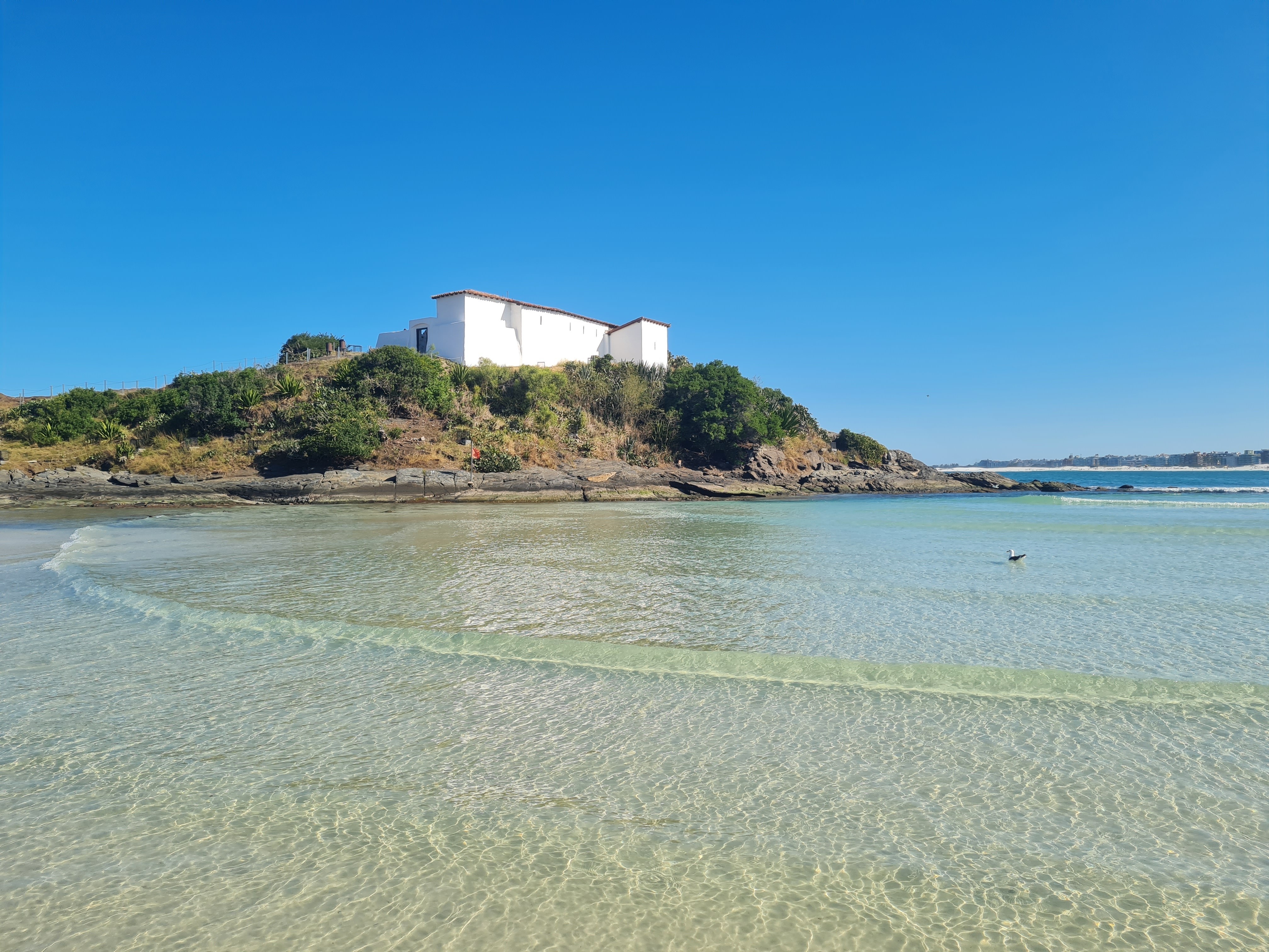 Praia do Forte em Cabo Frio com o Forte de São Mateus ao fundo e mar cristalino em primeiro plano