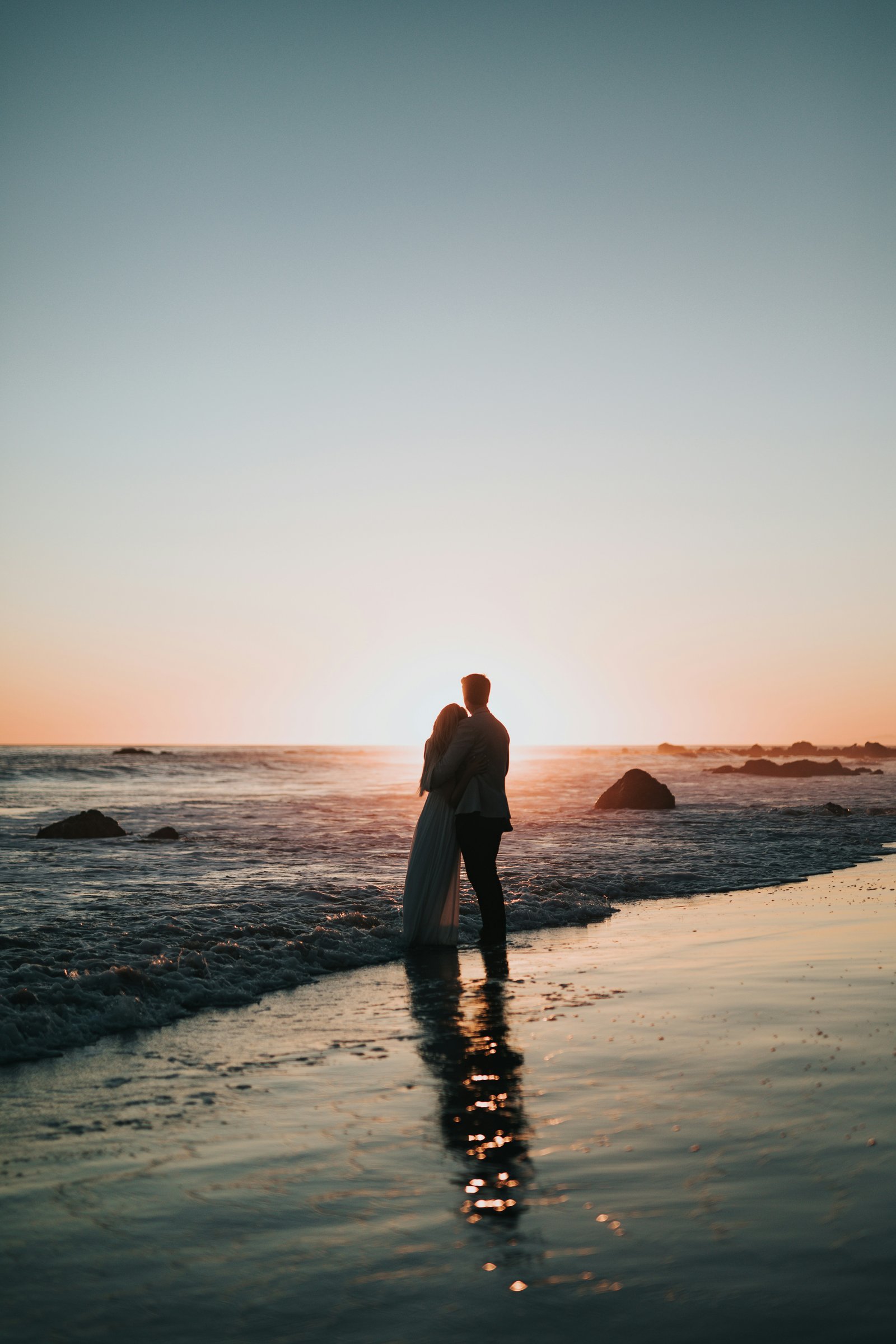 Casal silhueta abraçado no pôr do sol