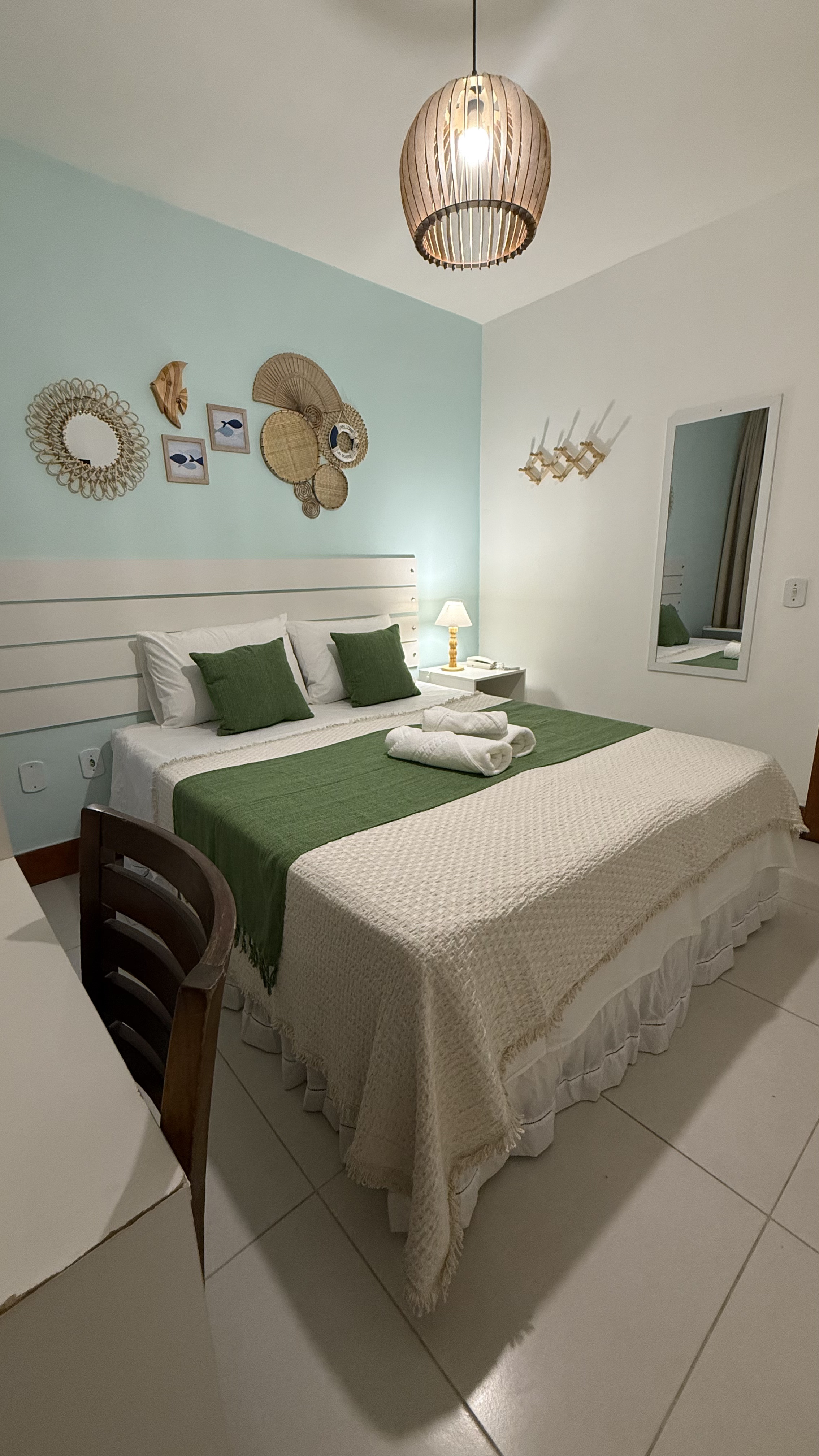Quarto Duplo Standard com parede azul tiffany e decoração de pratos de palha